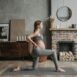 A pregnant woman doing yoga on a mat in a cozy living room setting.