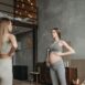 Expectant mother practicing prenatal yoga with guidance in a cozy home setting.