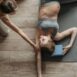 Pregnant woman practicing yoga with trainer, focused on relaxation and stretching, indoors.