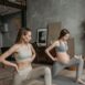 Two pregnant women performing yoga indoors, promoting a healthy lifestyle through exercise.