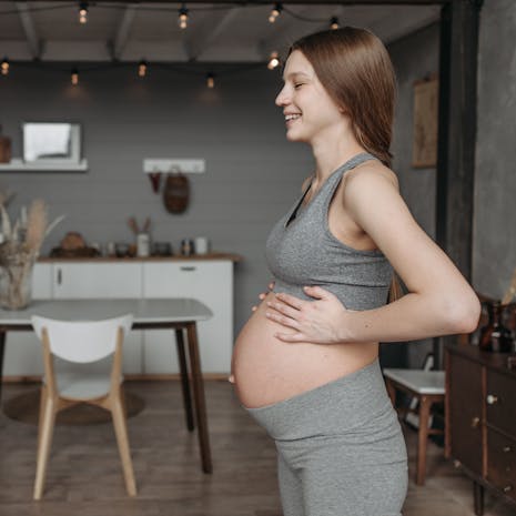 תמונה מאת Pavel Danilyuk Two women indoors sharing a healthy fitness routine during pregnancy, promoting wellness.